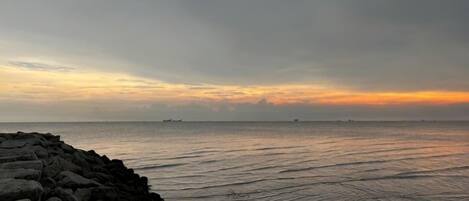 A coastal scene with a rocky shoreline and calm sea.