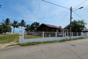 A house with a fenced yard, a paved road in front, and a clear sky. - Balek Kualé (Kuala Sungai Baru)