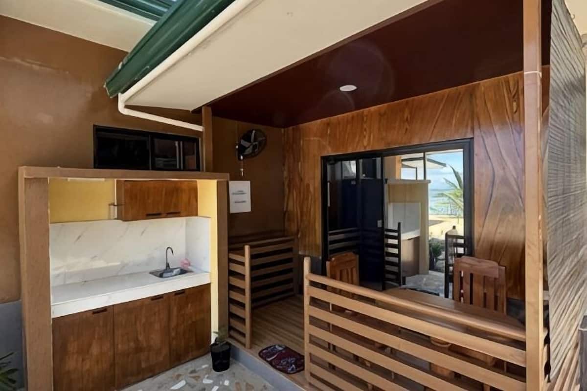 A compact kitchen with a sink, wooden cabinets, and a window.