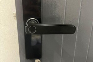 A black door handle on a gray door.