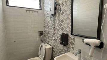 Een badkamer met toilet, wastafel en spiegel.