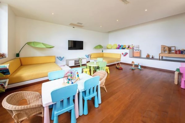 A spacious living area with a sofa, a table, and chairs. - Jasmine Waterslide 5BR Pool Villa (Koh Samui)