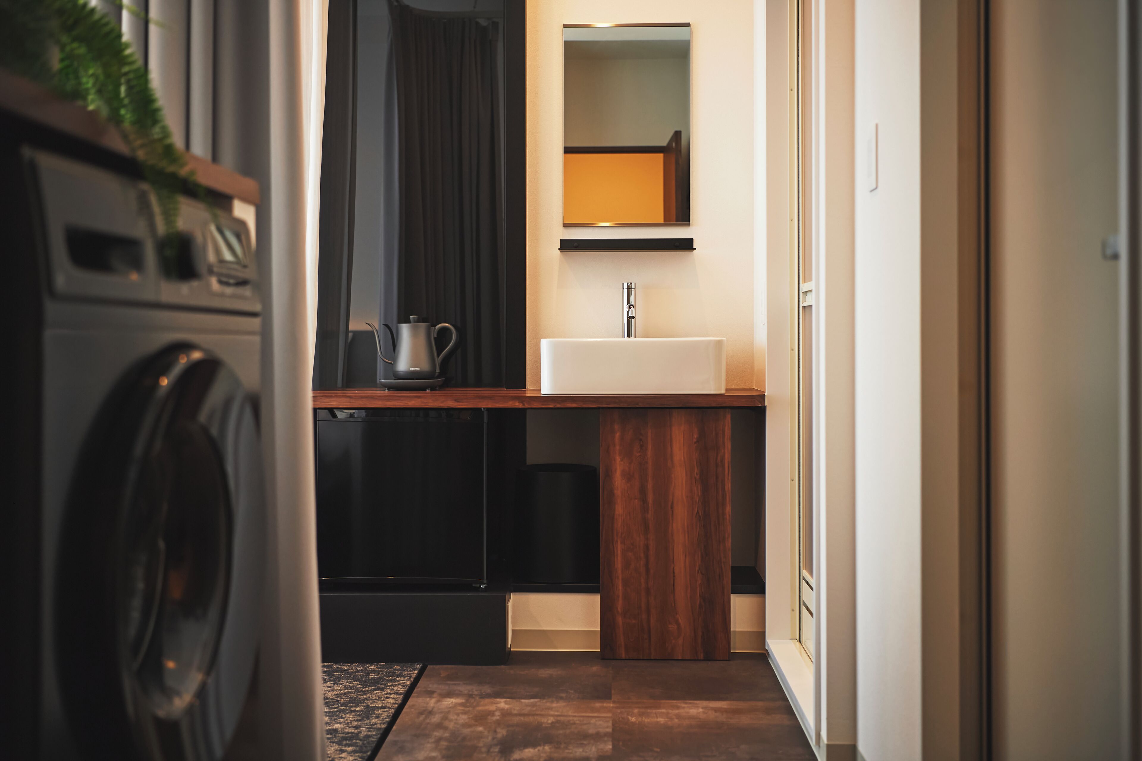A compact kitchen with a wooden countertop, a sink, and a mirror above it.