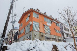 A multi-story building with a flat roof and a flat facade. - Yuzawa Onsen Lodge House A (Minamiuonuma)