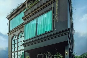 A multi-story building with large windows and a balcony. - The Black Kingdom (Bangkok)