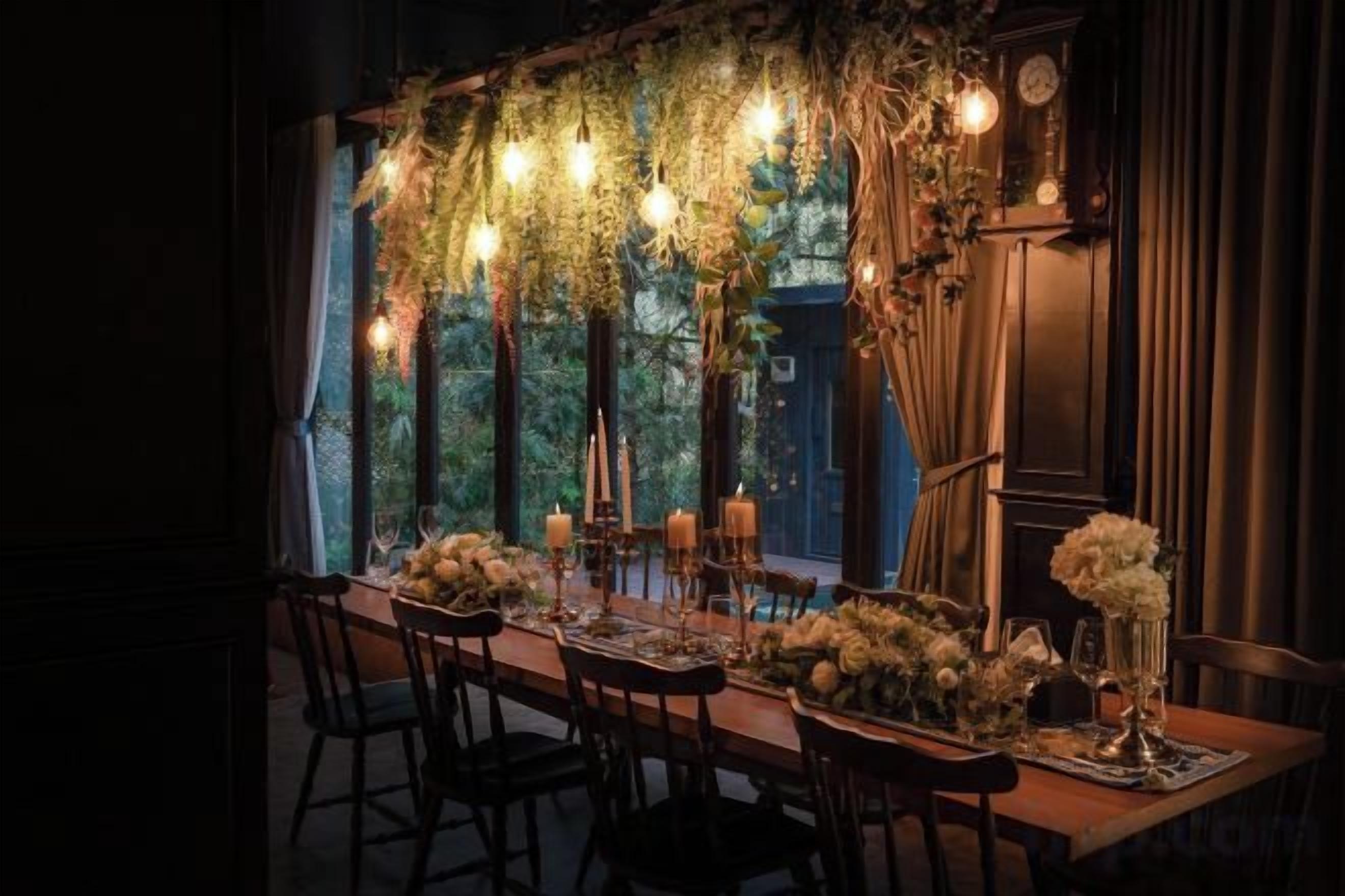 A dining table set with candles, flowers, and a chandelier.