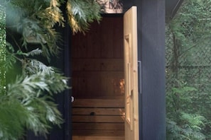 A sauna with a wooden interior and a door. - The Black Kingdom (Bangkok)