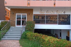 Un edificio con una escalera que lleva a una puerta, un cartel que dice 'New Nordic Trend 6' y un balcón con barandilla.