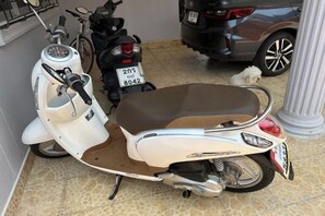 A white scooter with a brown seat parked indoors. - 2 Bedroom Condo in Pattaya (Jomtien Area, Pratamnak Hill, New North European Trend 6 Hotel Condo) (Pattaya)