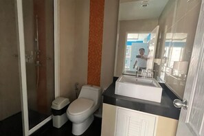 Un baño con inodoro, lavabo y ducha.