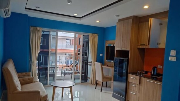 Una sala de estar moderna con un sofá, una mesita y vistas al exterior a través de una puerta de cristal.