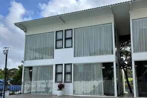 Un edificio de dos pisos con ventanas amplias y techo plano.
