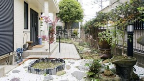 A garden with stone pathways, potted plants, and a small water feature. - Relaxing stay Fukunosou - Convenient Access Hakata (Fukuoka)