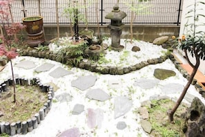A garden with stone pathways, potted plants, and a stone lantern. - Relaxing stay Fukunosou - Convenient Access Hakata (Fukuoka)