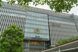 A modern building with a large clock on the facade, a tree in front, and a clear sky. - Relaxing stay Fukunosou - Convenient Access Hakata (Fukuoka)
