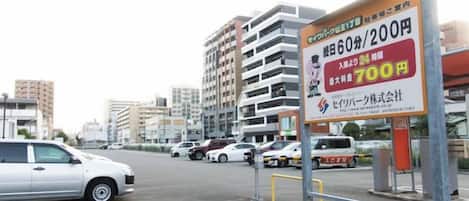 Un estacionamiento con un cartel que indica una tarifa de estacionamiento de 60 minutos por 200 yenes y una tarifa de 700 yenes por 2 horas.
