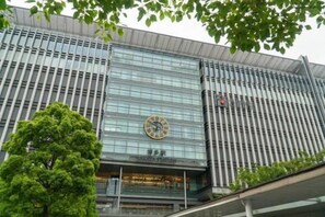 A modern building with a large glass facade and a prominent clock on the front. - Relaxing stay Fukunosou - Convenient Access Hakata (Fukuoka)