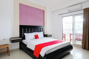 Une chambre d’hôtel moderne avec un grand lit, une table de chevet, une petite table et un balcon avec vue.