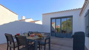 A patio with a table set for dining, chairs, and a grill. - Beach 400 m away - House for 4 with terrace (La Guérinière)