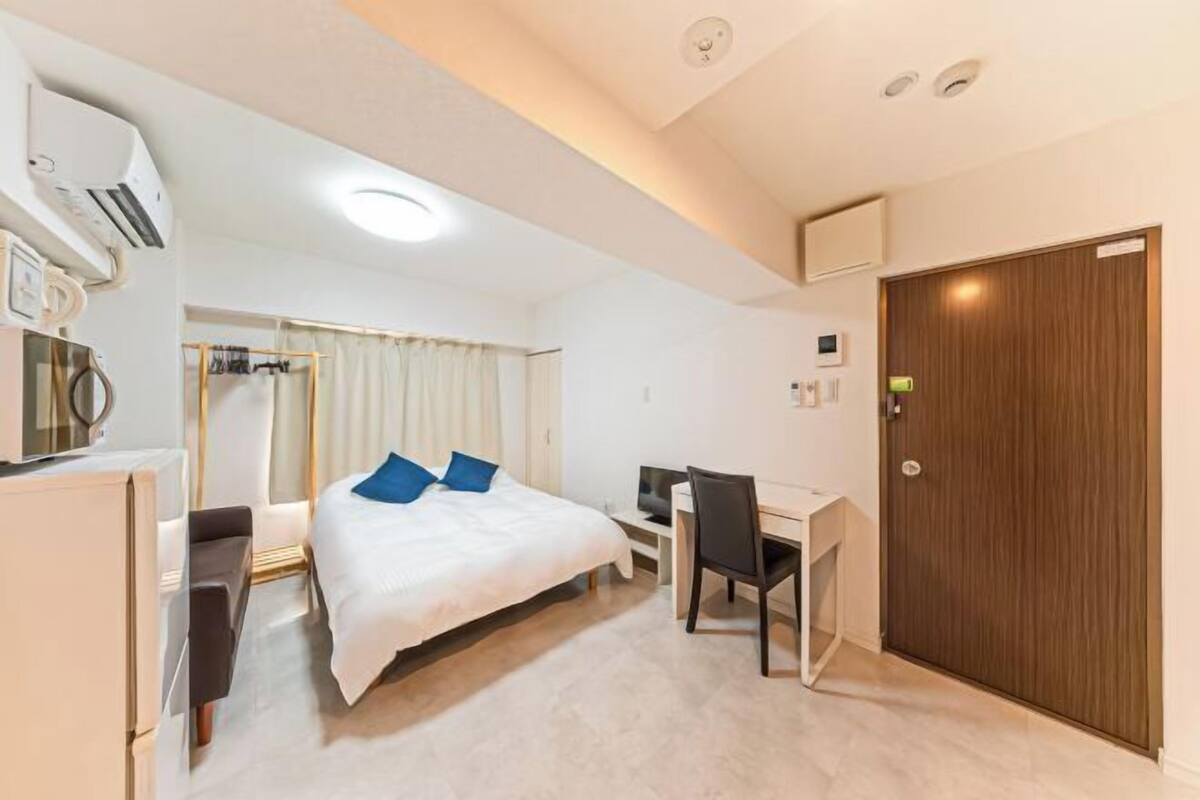 Hotellihuone, jossa on sänky, työpöytä, tuoli ja vaatekaappi.