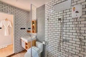 A modern bathroom with a white brick wall, a glass shower enclosure, a white toilet, and a wooden vanity. - The value of time pool villa Khaoyai (Pak Chong)