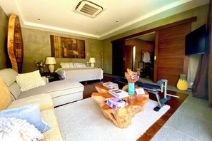 Un dormitorio moderno con cama, sofá, mesa de centro y televisor.