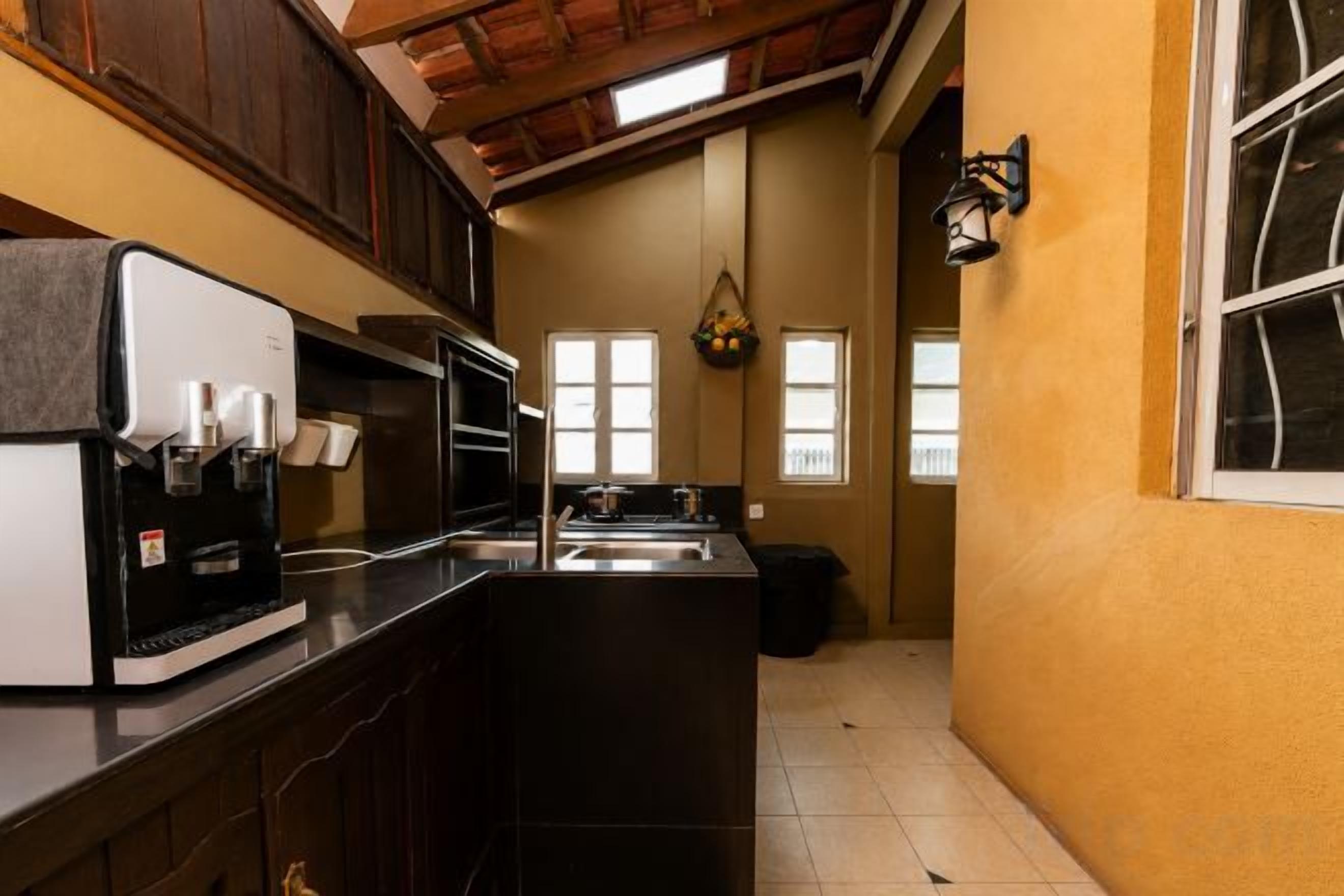 A kitchen with a coffee maker, microwave, and sink.