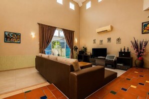 A living room with a sofa, a coffee table, a TV, and a fireplace. - Batu Pahat Santalia Villa 4BR 12pax Private Pool (Simpang Kanan)