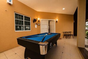 A pool table in a room with a window and a door. - Batu Pahat Santalia Villa 4BR 12pax Private Pool (Simpang Kanan)