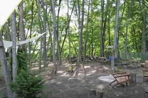 A forested area with a wooden bench and a picnic table.