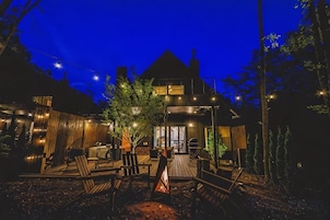 Una casa moderna con un patio que incluye mobiliario exterior y una chimenea.