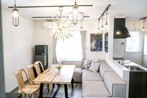 Una cocina moderna con zona de comedor, asientos integrados e iluminación colgante.