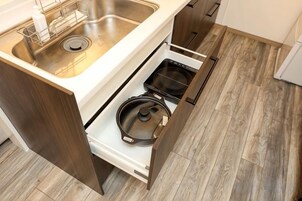A kitchen with a built-in stove, a sink, and a wooden floor.