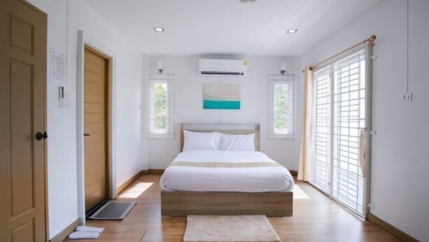 A bedroom with a bed, a window, and a door. - DeliZia de Villa Homestay Satun (Satun)