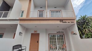 A two-story building with a balcony, a welcome sign, and a door. - DeliZia de Villa Homestay Satun (Satun)