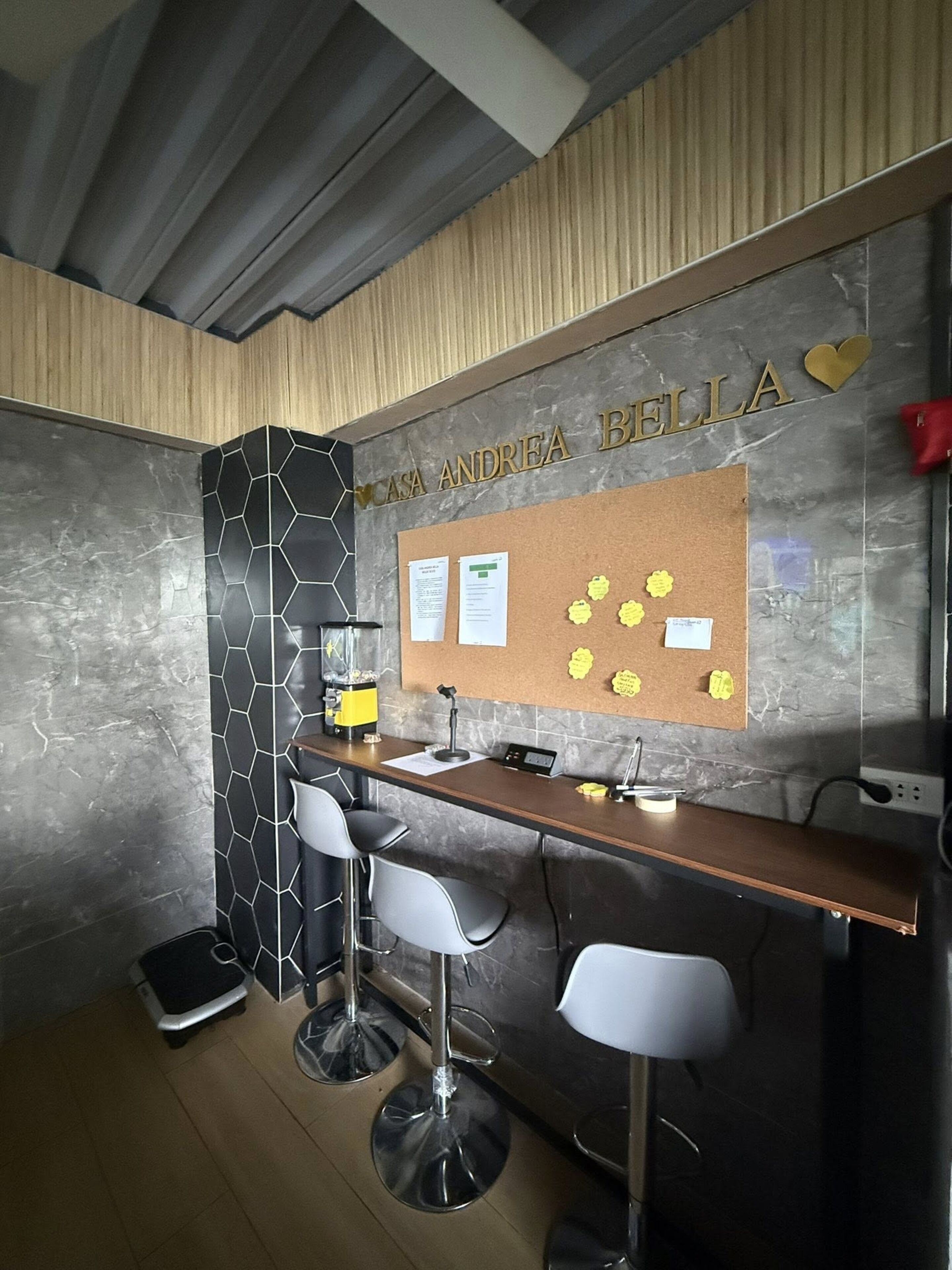 A bar area with a corkboard displaying notes and a name sign above it.