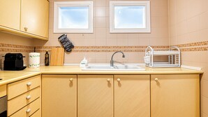 A kitchen with a sink, a microwave, and a window above the sink.