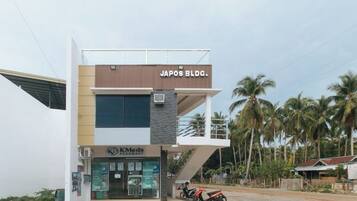 Un edificio con un cartel que dice 'JAPOS BLDG' y una farmacia llamada 'KMed Pharmacy' debajo.