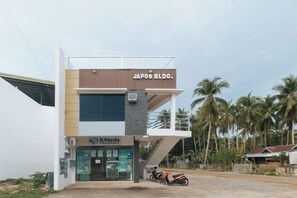A building with a sign reading 'JAPOS BLDG.' and a pharmacy named 'KMed Pharmacy' below it. - RedDoorz @ Happy Stay Apartelle (Dauis)