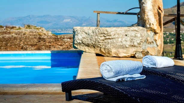 A poolside area with a view of mountains, a wooden structure, and a lounge chair with a towel. - Beautiful private villa for 10 people with A/C, WIFI, pool, TV and panoramic view (Scopello)