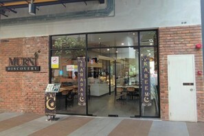L'ingresso di un ristorante con porta in vetro, facciata in mattoni e insegna con scritto 'Murn Discovery'.