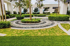 A landscaped courtyard with a circular garden, pathways, and trees. - Sunset Lake View at M-Luna Kepong by HCK (Kuala Lumpur)