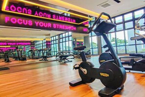 A gym with exercise equipment, a wooden floor, and large windows. - Sunset Lake View at M-Luna Kepong by HCK (Kuala Lumpur)