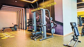 Een sportschool met trainingsapparatuur, een muur met motiverende tekst en een spiegelwand.