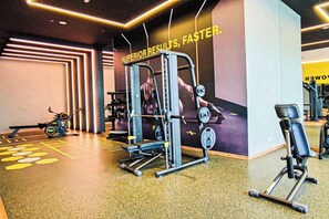 Una palestra con attrezzature per esercizi, un muro con scritte motivazionali e uno specchio a parete.