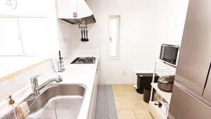 A kitchen with a stainless steel sink, a microwave, and a stove. - MoonLight inn Free parking (Dazaifu)