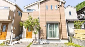 A residential building with a front entrance, a small tree, and a gravel driveway. - MoonLight inn Free parking (Dazaifu)