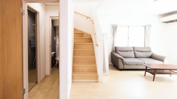 A modern living room with a staircase, a sofa, and a coffee table. - MoonLight inn Free parking (Dazaifu)