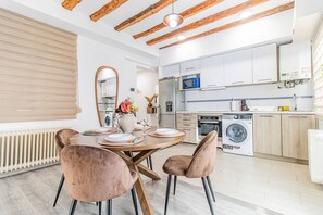 Forn, placa de cuina, torradora i una taula de menjador 