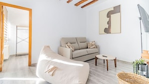 Un salon moderne avec un canapé, une table basse et un tableau au mur.